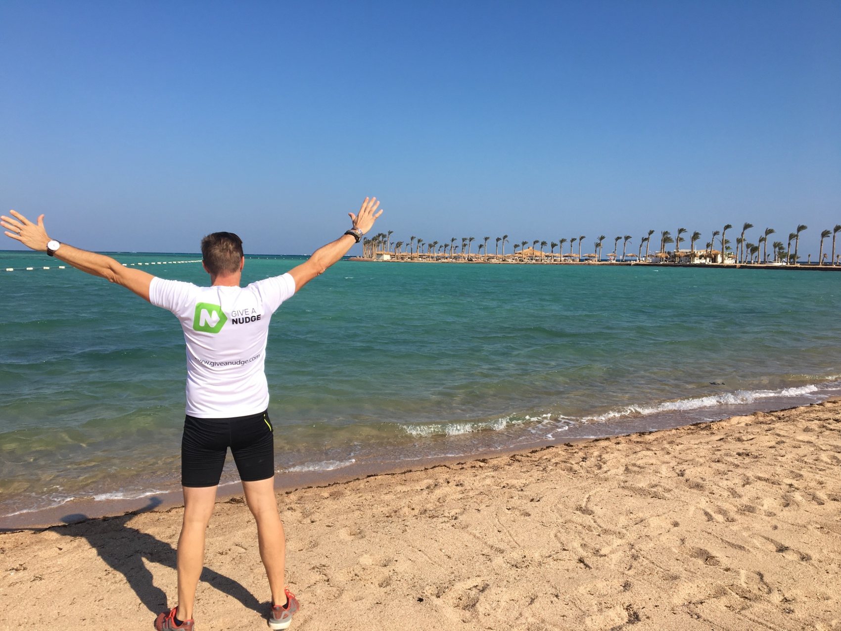 Give a Nudge running shirt by the sea